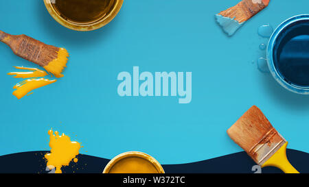 Painting concept composition with brushes and color boxes on blue desk. Copy space in the middle for text. Stock Photo