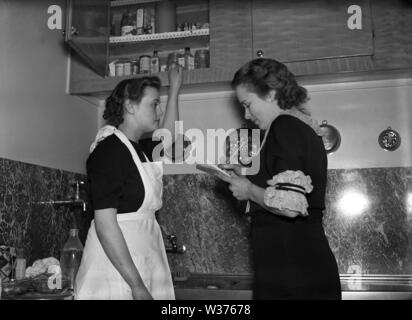 Living in the 1940s. A young woman working as a maid with the housewife  who writes a list of things to do and what to buy. Sweden 1940. Kristoffersson ref 55-6 Stock Photo