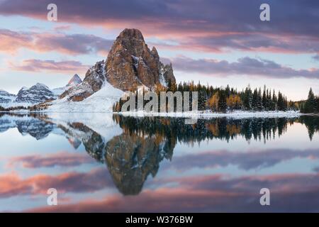 Winter sunset. Mount Assiniboine, also known as Assiniboine Mountain, is a pyramidal peak mountain located on the Great Divide on the British Columbia Stock Photo