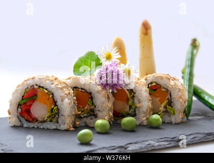 Sushi and Sashimi maki rolls nigiri and inside out maki rolls artistically arranged with regional ingredients Stock Photo