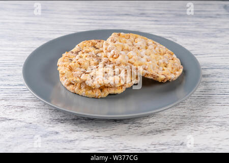 two dried corn tortillas on a gray plate on a white wooden table. Front view Stock Photo