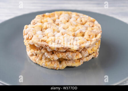 Three dried corn tortillas on a gray plate, on a white wooden table. Front view Stock Photo
