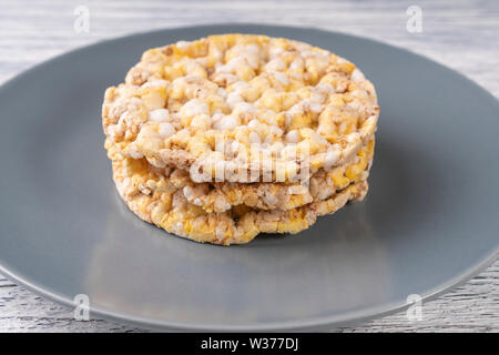 Three dried corn tortillas on a gray plate, on a white wooden table. Front view Stock Photo