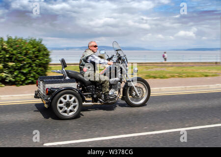 Morecambe, UK. 13th July, 2019. Morecambe Rides Again; The First Kick Scooter Collective and the Vespa Club of Morecambe (COG159) host a rally circuit in the resort which has the honour of being a Vespa Club Of Britain signing on event. Morecambe is back on the scootering map with the first proper scooter rally since the 1980s being held. Scooterists roared into town on their Vespas congregating at Happy Mount Park before a mass rally along the seafront promenade. Credit: Cernan Elias/Alamy Live News Stock Photo