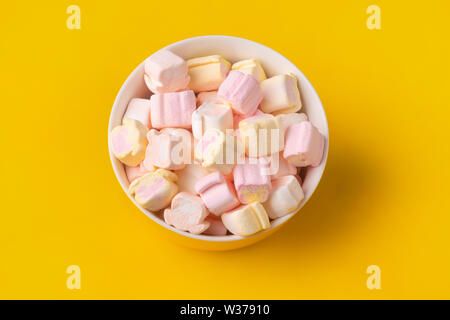 colorful marshmallows in plate on yellow background Stock Photo