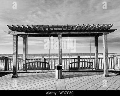 Gulf Shores, AL USA - 05/08/2019  -  Swings Overlooking The Beach in B&W Stock Photo