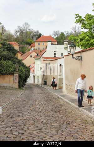 Prague, Czech Repulic - may 2016: People walking on old medieval narrow cobbled street and small ancient houses in Novy Svet, Hradcany district Stock Photo