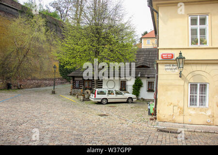 Prague, Czech Repulic - may 2016: White car parking near wall on old medieval narrow cobbled street and small ancient houses in Novy Svet, Hradcany di Stock Photo