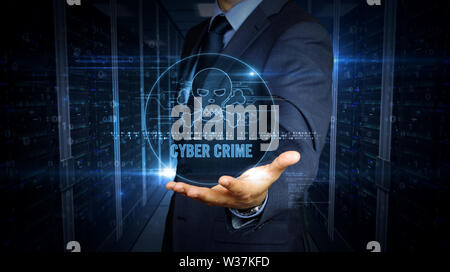 A businessman in a suit and screen with pirate skull symbol hologram. Man using virtual display interface. Cyber attack, online crime, theft and fraud Stock Photo