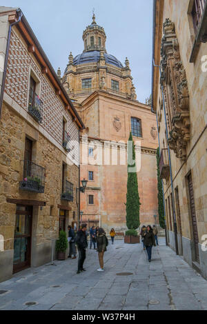 Narrow old street scene, La Clerecía an historic baroque Catholic church Salamanca Spain Stock Photo
