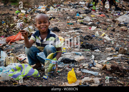 Bissau, Republic of Guinea-Bissau - February 8, 2018: Young african boy collecting garbage at a landfill in the city of Bissau, in Guinea-Bissau, West Stock Photo
