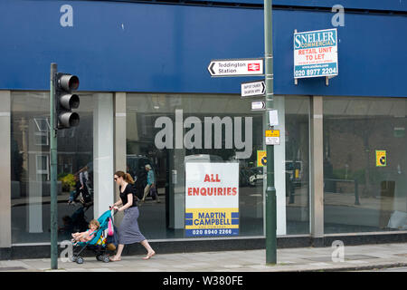 vacant shop with estate agents signs in teddington, southwest london, england Stock Photo