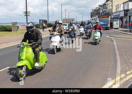 Scooter Rally Ride Out in Lancashire, UK July 2019. Morecambe Rides Again; The First Kick Scooter Collective and the Vespa Club of Morecambe (COG159) host a rally circuit in the resort which has the honour of being a Vespa Club Of Britain signing on event. Morecambe is back on the scootering map with the first proper scooter rally since the 1980s being held. Scooterists roared into town on their Vespas & Lambrettas congregating at Happy Mount Park before a mass rally along the seafront promenade. Stock Photo