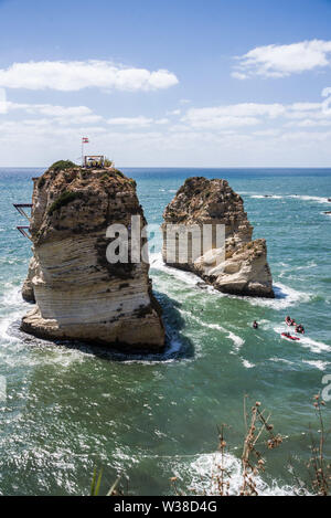 Cliff jumpers compete in Round 1 of 3 at Rouche Rocks in Beirut. Part of a RedBull sponsored world tour, high divers from all over the globe are taking part in a cliff diving competition from scenic locations across the planet. Jumping from heights in excess of up to 27m they encountered strong winds and rough seas today, continuing with the competition despite having to be zip-lined over to the dive platform due to strong waves preventing boat access. Stock Photo