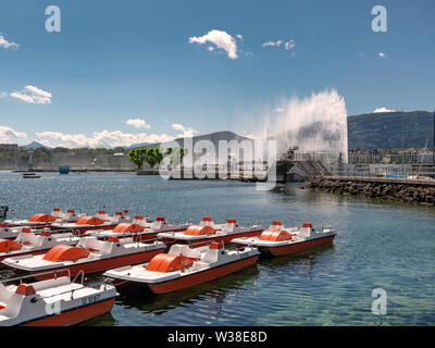 Pedal boats in the marina in Geneva. Jet d'Eau (water fountain) in the background. Stock Photo