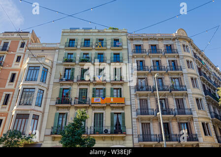 BARCELONA, SPAIN - NOVEMBER  03, 2018: Facades of buildings around Barcelona with some flags of Catalonia hanging on the balconies, Spain Stock Photo
