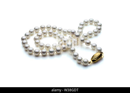 A single strand necklace of white pearls with a gold clasp are crossed over itself. Shown on a white background with shadow.