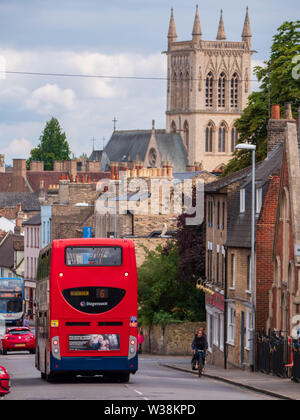 A red double-decker bus drives down castle hill in Cambridge. Stock Photo