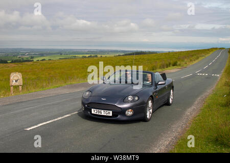 2001 Aston Martin DB7 Vantage Volante at Scorton, Lancashire. UK Weather 13th July 2019. Sunny conditions as the Lancashire Car Club Rally Coast to Coast crosses the Trough of Bowland. 74 vintage, classic, collectable, heritage, historic vehicles left Morecambe heading for a cross-county journey over the Lancashire landscape to Whitby. A 170 mile trek over undulating landscape as part of the classics on tour car club annual event. Stock Photo