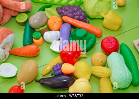 Toy fruits and grasszs . Fake fruits and vegetables .Plastic childrens toys in the form of fruit and vegetables Stock Photo