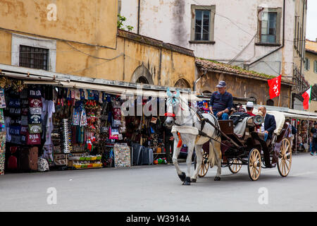 PISA, ITALY - APRIL, 2018: Tourists on a horse drawn carriage in Pisa Stock Photo