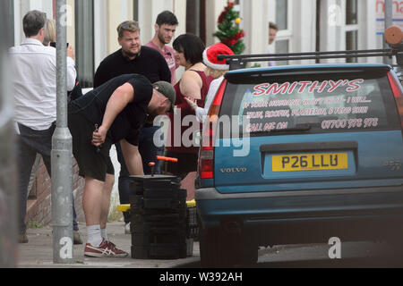 Barry, UK. 13th July, 2019.  Co writer and star James Corden who plays 'Smithy' and co-writer Ruth Jones who plays 'Nesa' and Joanna Page who plays 'Stacey' rehearse a scene during filming of the BBC comedy Gavin & Stacey Christmas special in Trinity Street, Barry, South Wales. Credit: Mark Lewis/Alamy Live News Stock Photo