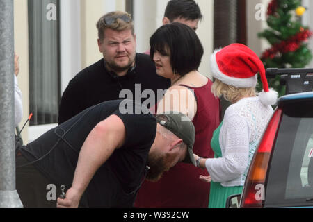 Barry, UK. 13th July, 2019.  Co writer and star James Corden who plays 'Smithy' and co-writer Ruth Jones who plays 'Nesa' and Joanna Page who plays 'Stacey' rehearse a scene during filming of the BBC comedy Gavin & Stacey Christmas special in Trinity Street, Barry, South Wales. Credit: Mark Lewis/Alamy Live News Stock Photo