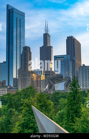 The beautiful Chicago skyline on a clear summer evening highlighting Maggie Daley Park, the Jay Pritzker Pavilion, and the Sears Tower. Stock Photo