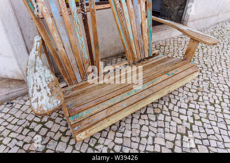 Old wooden bench on cobbled sidewalk in Lisbon, Portugal Stock Photo