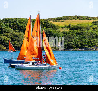 Squib class of yachts raising sails Stock Photo