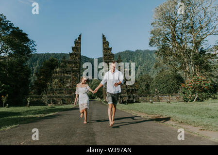 Couple of travelers at Handara Gate in Bali - Indonesia - Two tourists exploring Bali landmarks Stock Photo