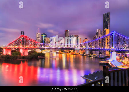 Brightly illuminated Story bridge over Brisbane river in Brisbane city CBD before sunrise when urban lights reflect in still waters. Stock Photo