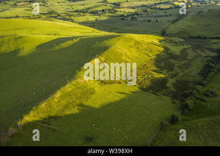 Aerial view over green hills of countryside fields in soft warm sunset light. Shropshire in United Kingdom Stock Photo