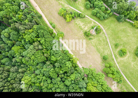 green landscape with country road in the field near  deciduous forest. natural rural landscape, aerial top view Stock Photo