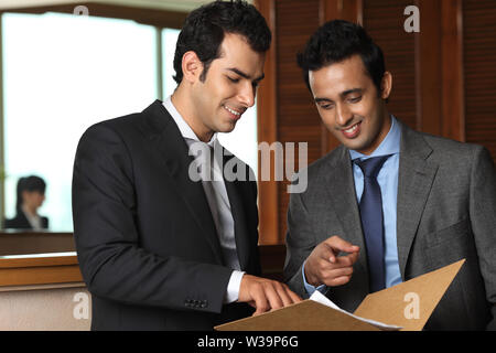 Two businessmen discussing documents in office Stock Photo