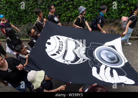Hong Kong, China. 14th July, 2019. Silent march in Hong Kong to stop police violence and defend press freedom sees working press, journalism students and their educators both past and present gather to protest. Protesters walk the perimeter of he Police Headquarters.The crowd wore all black in a show of solidarity. Credit: Jayne Russell/Alamy Live News