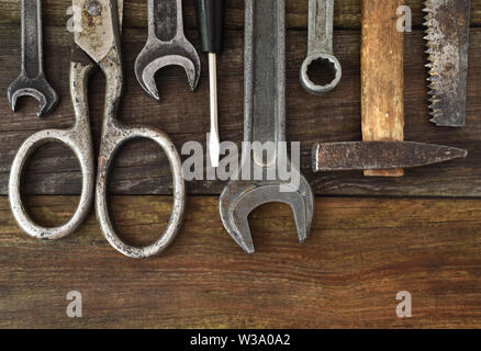 Retro vintage woodwork equipment set. Hammer scissors screwdriver on brown texture wooden planks background. Old carpentry rusty tools handy craft Stock Photo