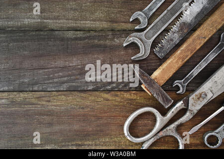 Retro vintage woodwork equipment set. Hammer scissors screwdriver on brown texture wooden planks background. Old carpentry rusty tools handy craft Stock Photo