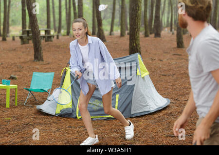 young couple playing badminton while on camping trip Stock Photo