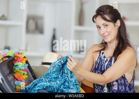 attractive woman packing her suitcase Stock Photo