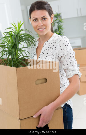 female holding a box containing a plant Stock Photo