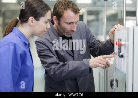 man and woman apprentice with machine cnc Stock Photo