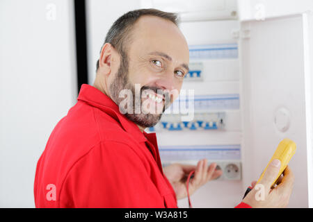 electrician installing energy saving meter Stock Photo