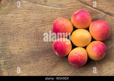 Apricots on wooden background assembled in the form of flower, flat lay photography Stock Photo