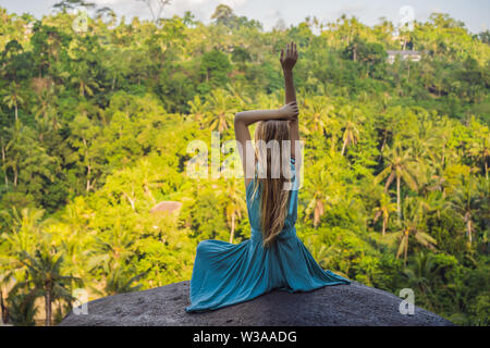 Young woman practicing yoga or pilates at sunset or sunrise in beautiful mountain location Stock Photo