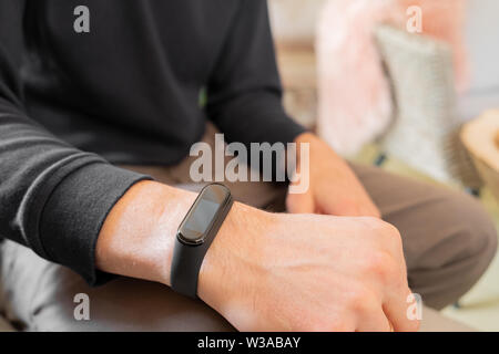 Fitness band on human's hand. Close-up view of male person's wrist with a smart watch on it Stock Photo
