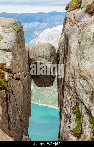 Kjeragbolten, the stone stuck between two rocks with fjord in the background, Lysefjord, Norway Stock Photo