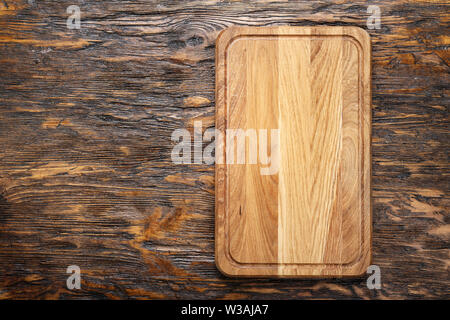 Rectangular wooden cutting board made of light wood as a background - space for text. on brown wooden background Stock Photo