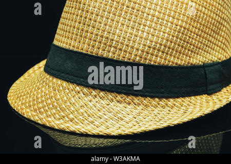Close up Straw hat on a black glass table background. Stock Photo