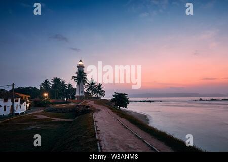 Beautiful historical lighthouse in fort in Galle. Old town in Sri Lanka at colorful sunrise. Stock Photo
